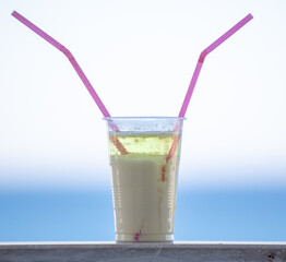 Milkshake with alcohol in a glass with a straw.