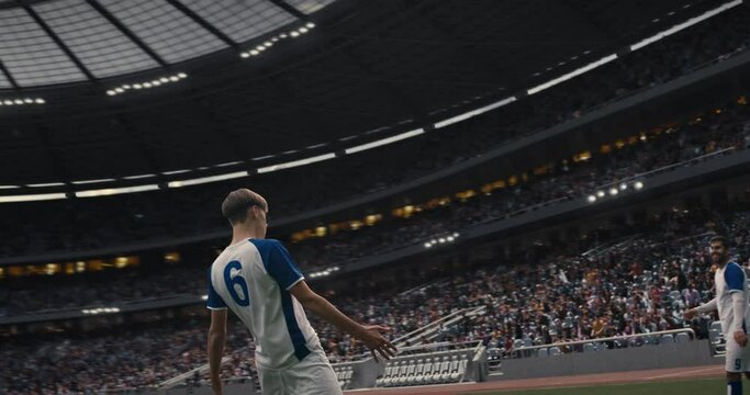 This video captures a triumphant moment in a football match as a player in a white and blue jersey celebrates scoring a goal