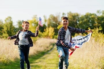 Tuinposter Two brothers running with USA flag. America holiday. Proud to be children of country. © AS Photo Family