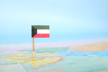 Selective focus of Kuwaiti flag in world map. Kuwait country location and sovereignty concept.