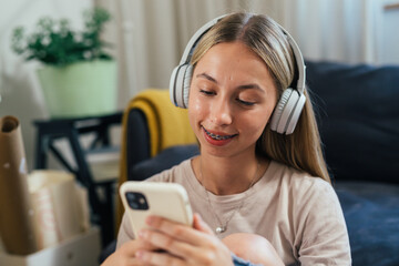 caucasian female with headphones using smartphone