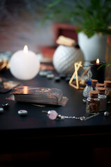 Blurred still life with vintage esoteric magic objects and old tarot cards on witch table altar for mystic rituals and fortune telling.