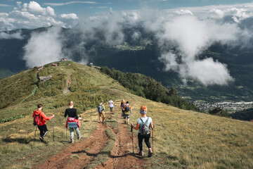 Obraz premium Young hikers trekking in Svaneti, Georgia. Shkhara mountain in the background. Amazingly beautiful WORLD. Fantastic sky background with blue clouds.