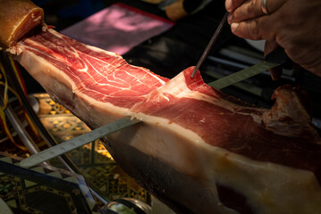 Cutting ham with tongs. Typical Spanish product