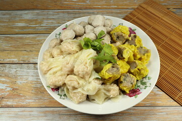 Pile of steamed wonton serving on the plate. Famous traditional dim sum menu in Chinese restaurant. 