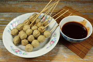 Pile of grilled pork ball serving on the plate. Famous street food menu in Asia. 