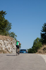 Cycliste arrivant au sommet du cil de Tourniol (Drôme) en face d'une voiture