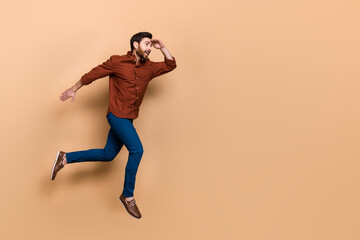 Fototapeta na wymiar Full length profile photo of overjoyed person jump run look empty space hand touch forehead isolated on beige color background