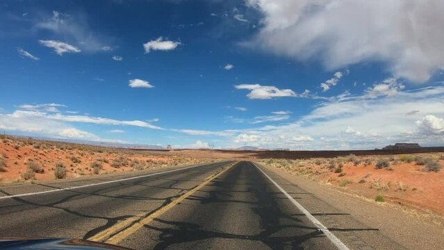 TRAVELING CAR SLOW MOTION SHOT - Drive through Highway 98, from the northwest, with the LeChee Rock in the background, Page, Arizona, USA.