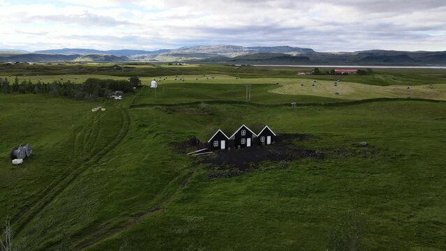 Aerial view of turf house in Island. Iconic small Iceland's house surrounded by green field.