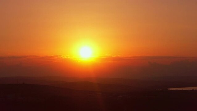 Aerial drone view of sunset. Hills, bright Sun, lake