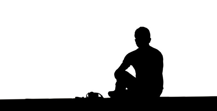 silhouette man and camera sitting floor