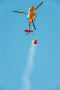 Helicopter transporting water to put out a forest fire