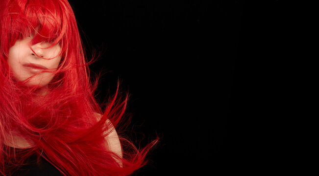 Dyed hair care and fashion concept. Fashion model girl with windswept long dyed red hair