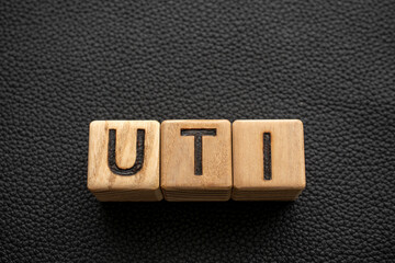 UTI - acronym from wooden blocks with letters, abbreviation UTI  urinary tract infection concept,...
