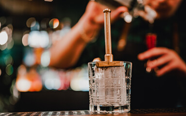 man bartender hand making negroni cocktail. Negroni classic cocktail and gin short drink with sweet vermouth, red bitter liqueur