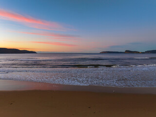 Gentle sunrise seascape with light scattered high cloud