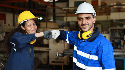 Happy smiling teamwork technician engineer or worker in protective uniform and hardhat make fist...