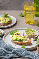 Healthy toast with avocado cream cheese and wheat bread on a plate. Delicious snacks and avocado sandwiches. Food composition, tasty Italian meal.