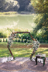 Wedding arch decorated with white flowers and greenery outdoors, copy space. Wedding setting....