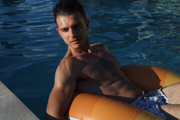 portrait of wet young man in a swimming pool