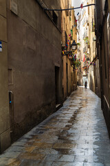 Fototapeta na wymiar Barcelona wet narrow street with reflections