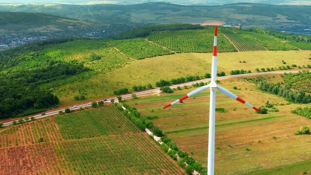 A working windmill in a field. Cloody weather, a lot of greenery around it