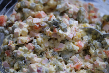 Traditional Russian Olivier salad of boiled sausage pickled green peas, eggs and mayonnaise