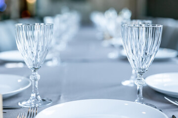Empty wine glasses are on the table in the restaurant. Fragment of table setting