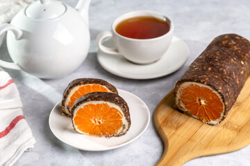 Sweet chocolate roll with tangerine filling and a cup of hot tea.