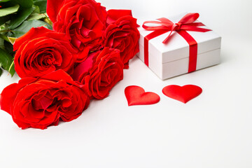 Obraz na płótnie Canvas Gift box, rose flowers and decorative hearts on a white background