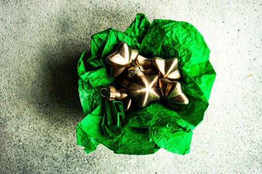 Overhead view of gold star shaped Christmas baubles in a box