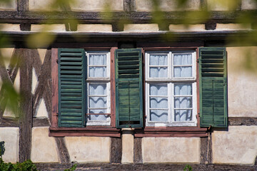 Grüne Holzfensterläden in einer alten Fachwerkfassade