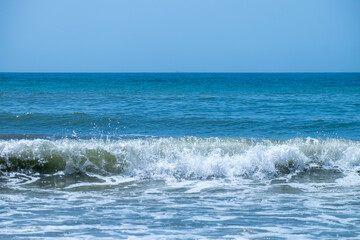 Ocean waves crashing on sandy beach. Sea waves breaking on Maditerranean's shore.