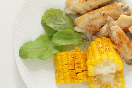 Barbecue chicken wing and sweet corn seed with salad for summer outdoor food image