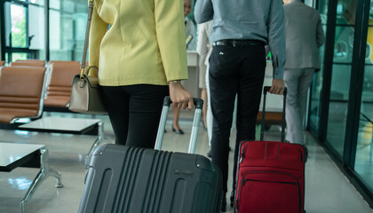 Passengers carries luggage at the airport terminal. ..Group of Passengers walking in the airport corridor with suitcase.  travel concept...