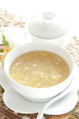 Homemade Chinese corn soup in white bowl with tea