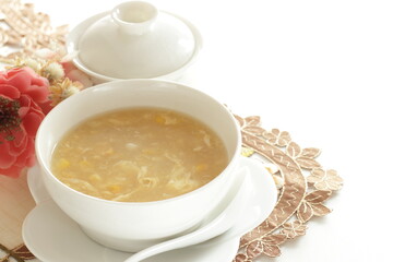 Homemade Chinese corn soup in white bowl with tea