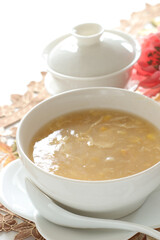 Homemade Chinese corn soup in white bowl with tea