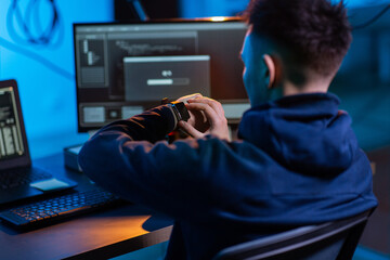 cybercrime, hacking and technology concept - close up of male hacker in dark room with smart watch...
