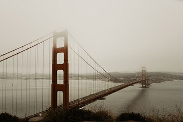 View of golden gate bridge from scenic viewpoint and travel destination with the city in the background. Morning with fog and overcast weather. Photo taken in San Francisco, California, USA