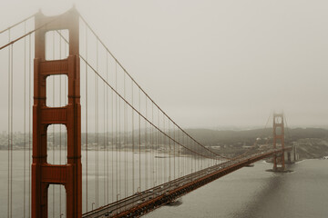 View of landmark golden gate bridge from scenic viewpoint  and travel destination with the city in the background. Morning with fog and overcast weather. Photo taken in San Francisco, California, USA