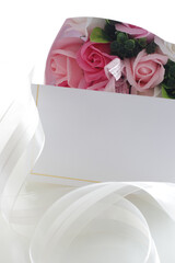 Blank card and artificial soap rose bouquet for holiday background image