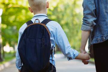 mother and son going to school holding hands