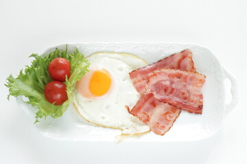 Bacon and sunny side up fried egg for homemade breakfast image
