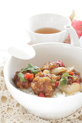 Chinese food, sour and sweet chicken on ricewith coriander leaves 