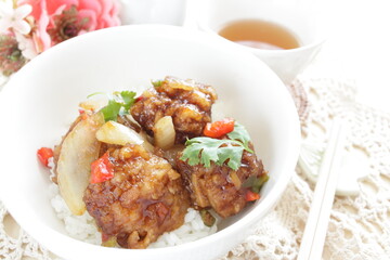 Chinese food, sour and sweet chicken on ricewith coriander leaves 