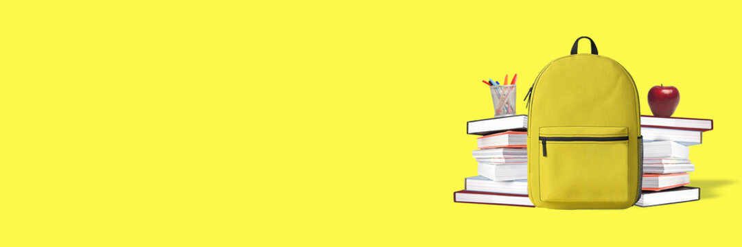 Back to school. Yellow backpack with books and school stuff on blue background 