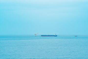 foggy seascape with a tanker near an oil terminal located far out to sea