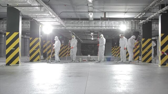 Builders in protective suits at the construction site. Professional builders at the construction site. Builders build underground parking
